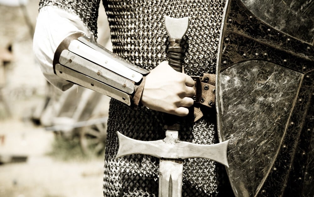 A valiant knight in steel armor, holding a medieval sword and shield, protecting nonprofit trademark 