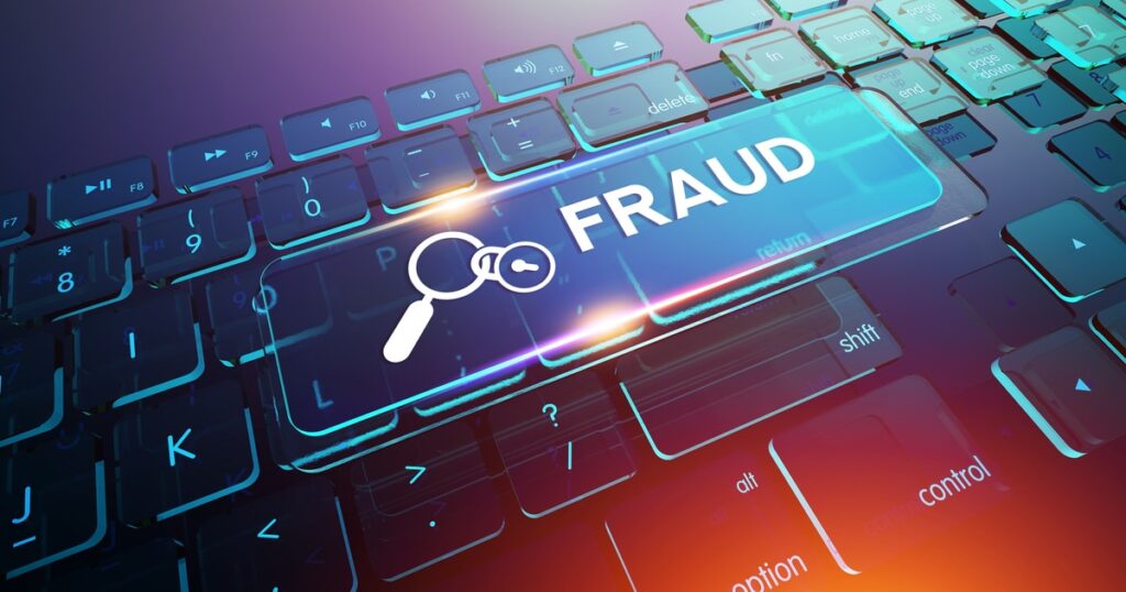 An illuminated fraud signal hovers over a laptop, warning of possible trademark scams.