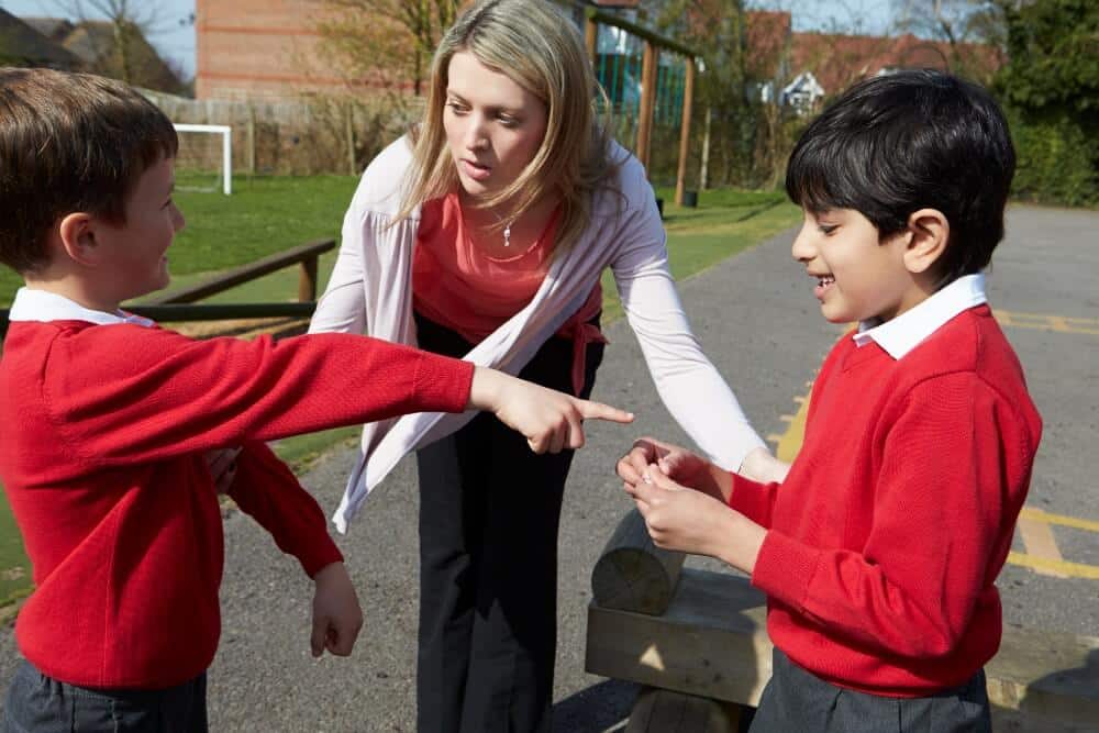 Teaching enforcing classroom management policy on the playground, breaking up a verbal fight between two boys