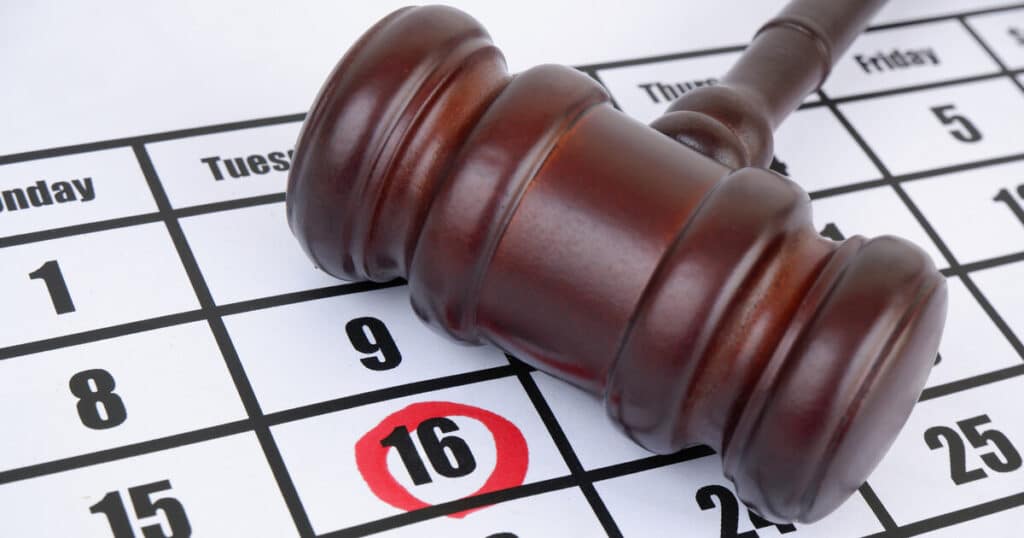 A gavel on a calendar with a date encircled in red reminds us that timing matters in workers comp cases and can be a decisive factor in determining when to hire a workers comp lawyer.