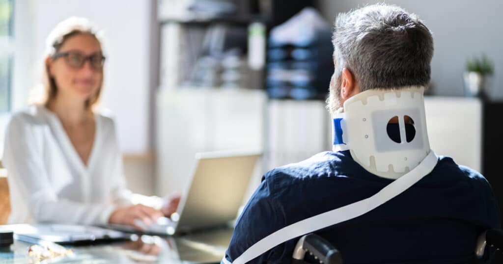 A smiling lawyer helps an injured worker who was aware of workers comp lawyer costs and decided the benefit of talking to her outweighed the risk.