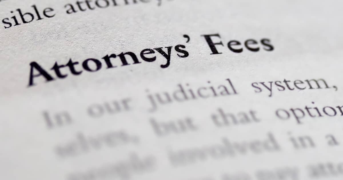 A page from a book says "Attorneys' Fees" and reminds us that injured workers often wonder , "What does a workers comp lawyer cost?"