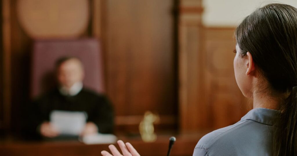 What happens if you cause an accident without insurance? A woman in a courtroom learns what happens.