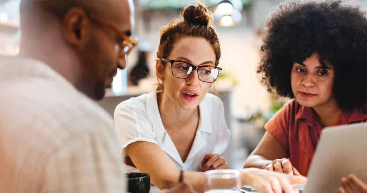 Three people meet together to learn about how to become a scholarship granting organization.
